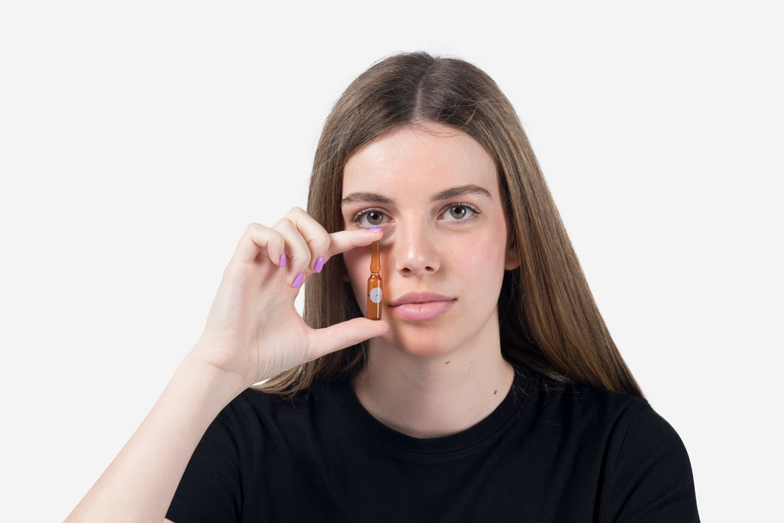 Young model holding a facial ampoule