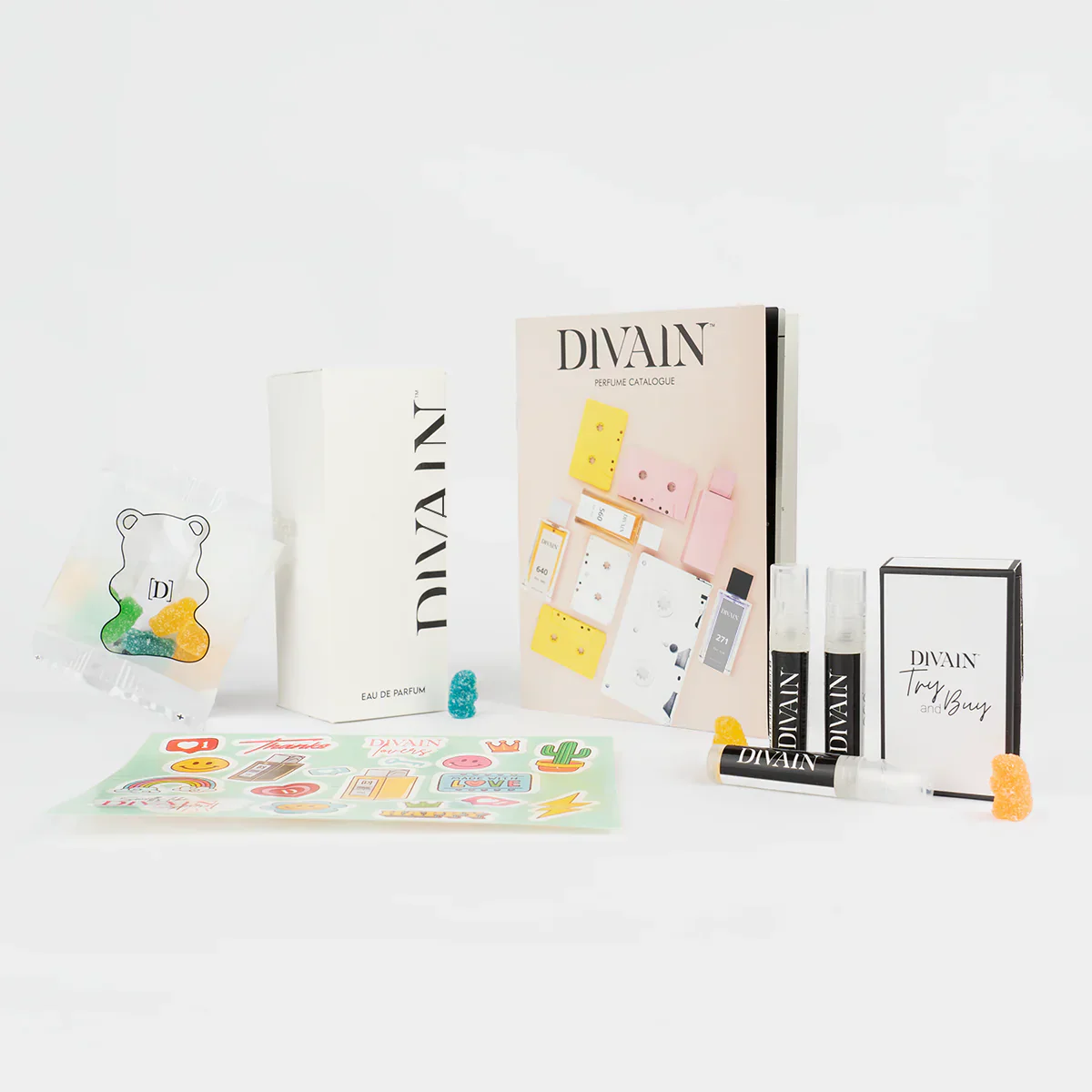 Opened divain package containing divain-845 perfume, stickers, and gummy candies
