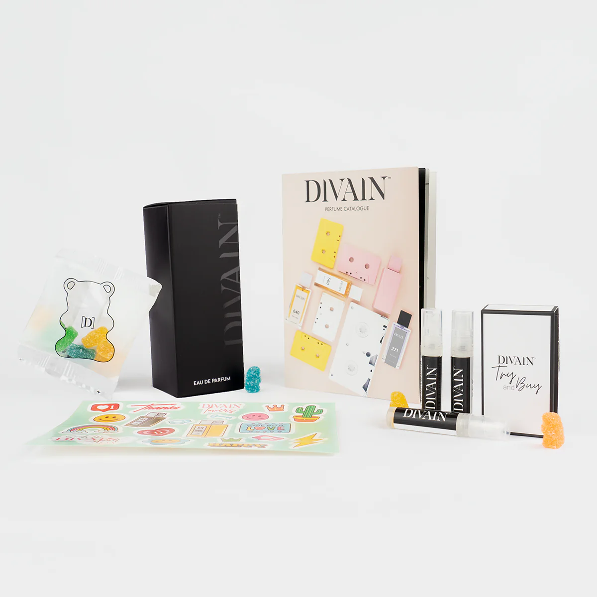 Opened divain package containing divain-458 perfume, stickers, and gummy candies
