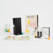 Opened divain package containing divain-467 perfume, stickers, and gummy candies
